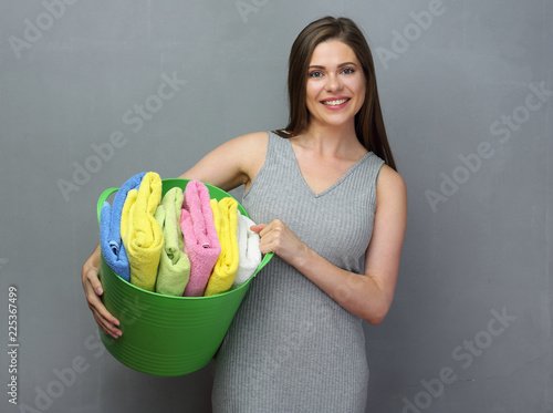  woman holding laundry basket with towels or clothes and deterge photo