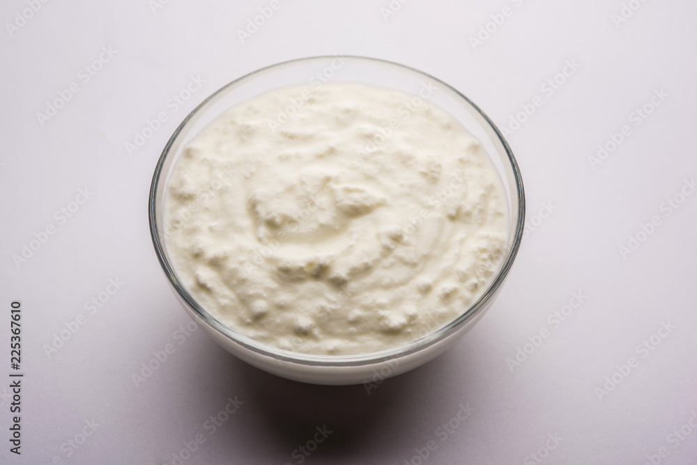 Plain curd or yogurt or Dahi in Hindi, served in a bowl over moody background. Selective focus Plain curd or yogurt or Dahi in Hindi, served in a bowl over moody background. Selective focus