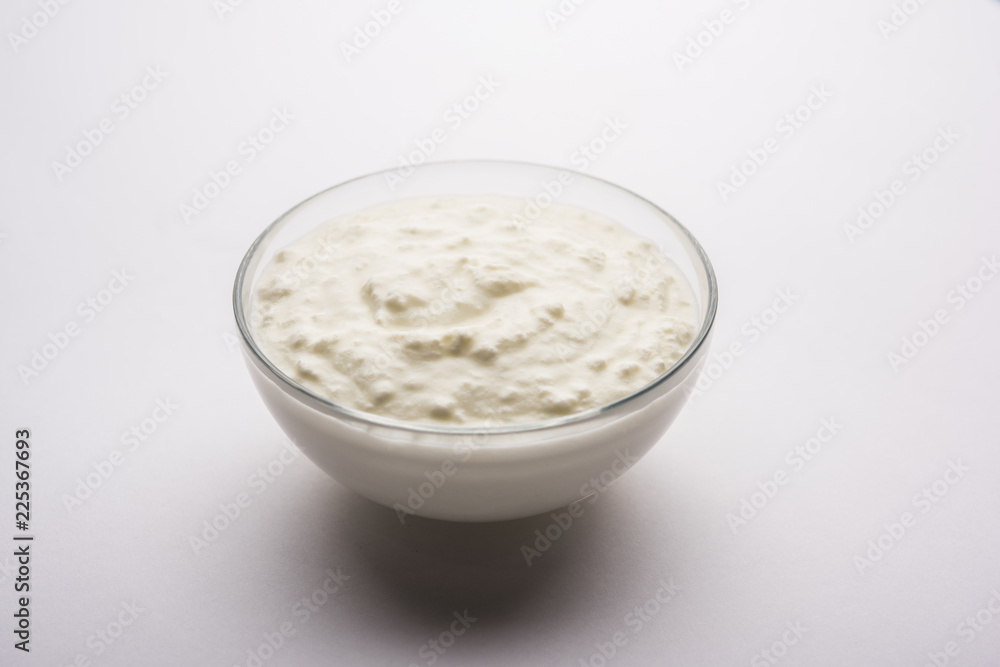 Plain curd or yogurt or Dahi in Hindi, served in a bowl over moody background. Selective focus Plain curd or yogurt or Dahi in Hindi, served in a bowl over moody background. Selective focus