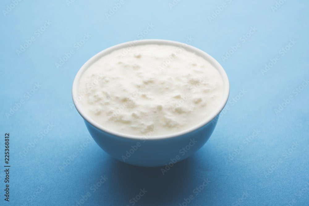 Plain curd or yogurt or Dahi in Hindi, served in a bowl over moody background. Selective focus Plain curd or yogurt or Dahi in Hindi, served in a bowl over moody background. Selective focus