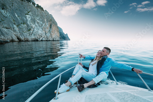 Young Couple Relaxing on a Yacht. Happy wealthy man and a woman by private boat have sea trip. © kuznetsov_konsta