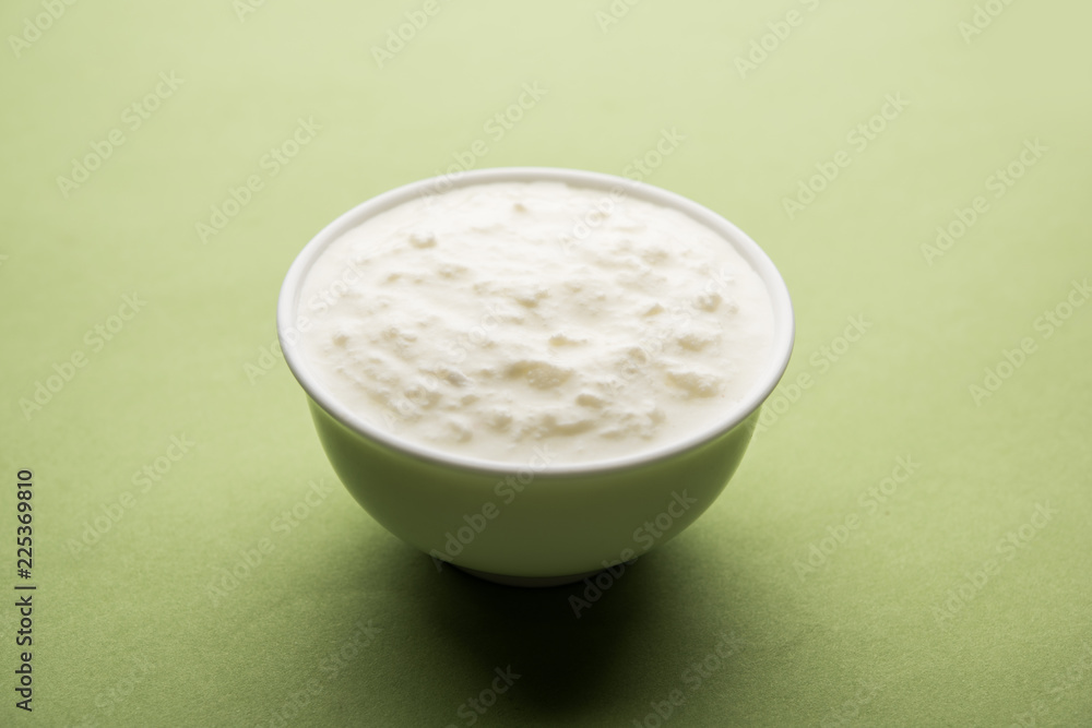 Plain curd or yogurt or Dahi in Hindi, served in a bowl over moody background. Selective focus Plain curd or yogurt or Dahi in Hindi, served in a bowl over moody background. Selective focus