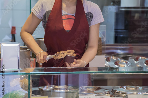 Wallpaper Mural horizontal image of woman's hands at work in an ice cream shop preparing a chocolate ice cream. Torontodigital.ca