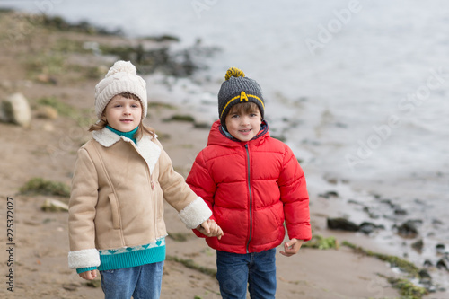 Two little children boy and girl playing and having fun together autumn outdoors