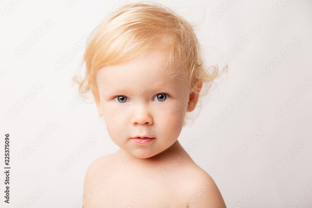 portrait of a little baby girl with blue eyes and curly hair, on a white background, closeup. concept childhood portrait of a little baby girl with blue eyes and curly hair, on a white background, closeup. concept childhood