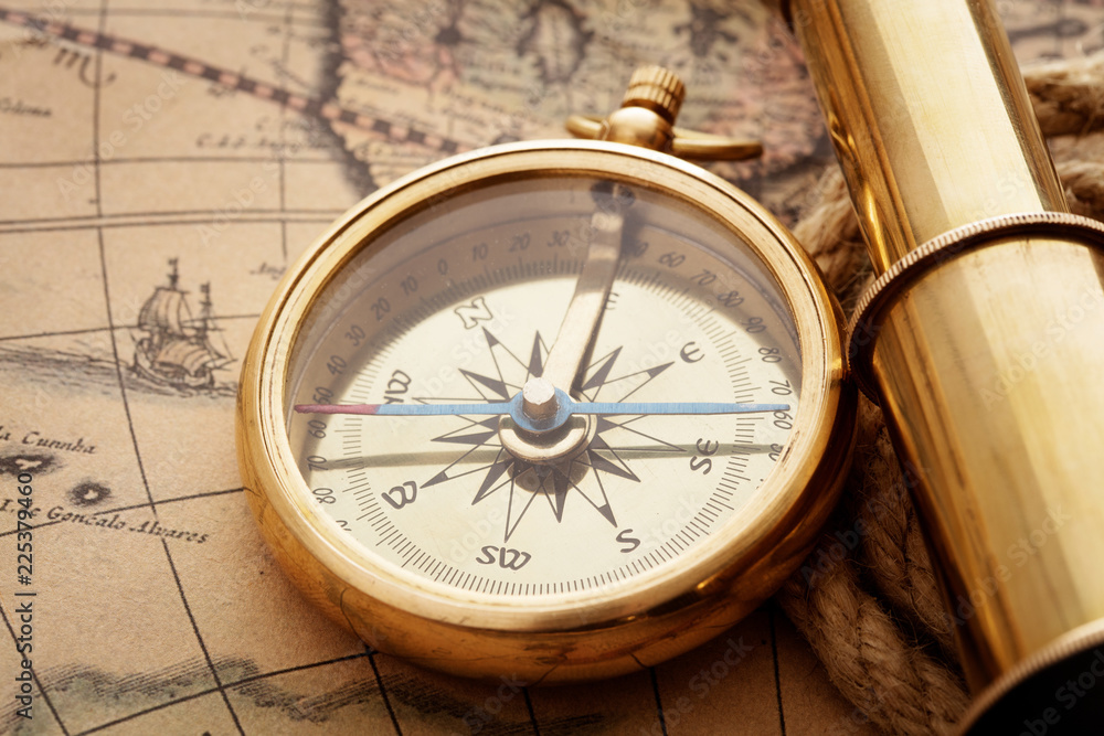 compass and spyglass on old map