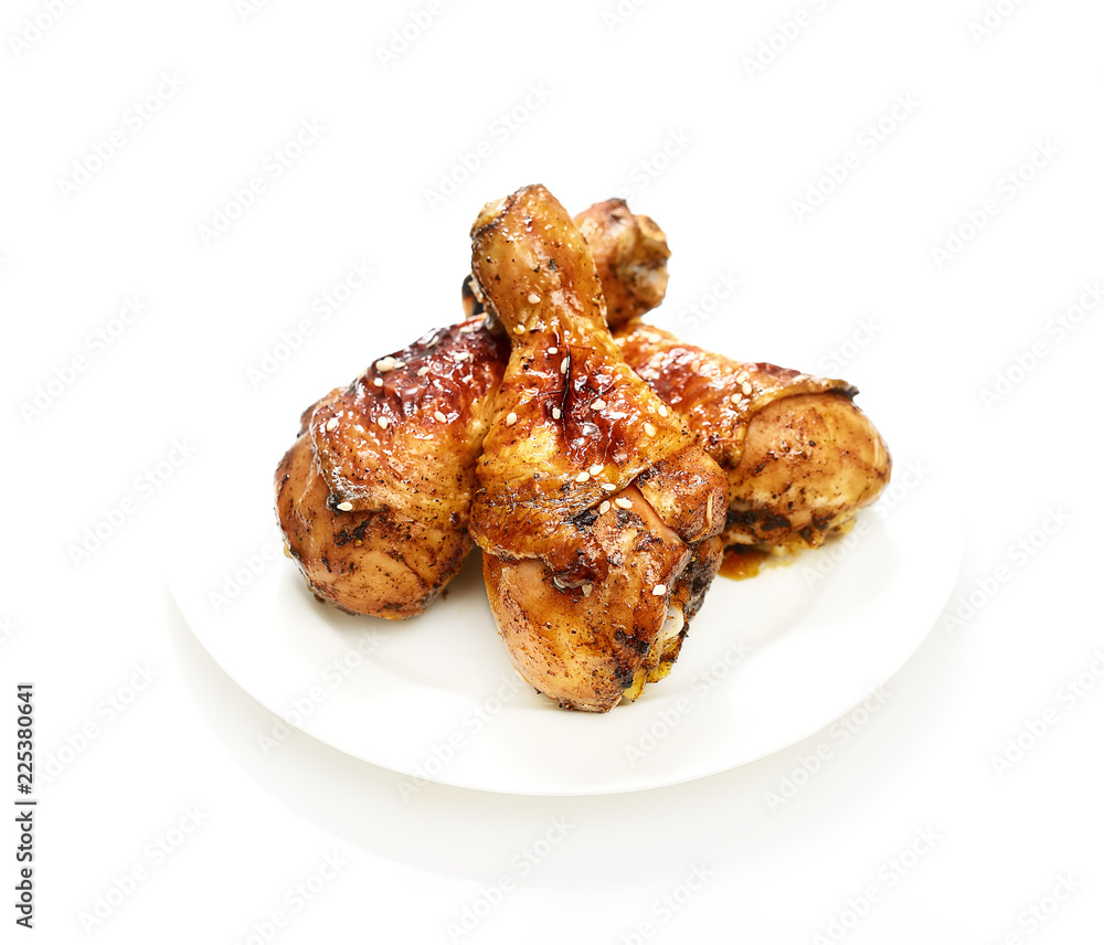 grilled chicken legs with sesame in a plate on a white background grilled chicken legs with sesame in a plate on a white background