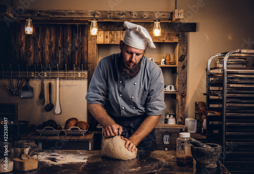 Fotografie, Obraz Concentrated chef kneading dough in the kitchen.
