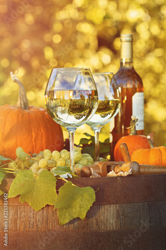 Fototapeta Naklejka Na Ścianę i Meble -  Glasses of white wine with pumpkins on barrel
