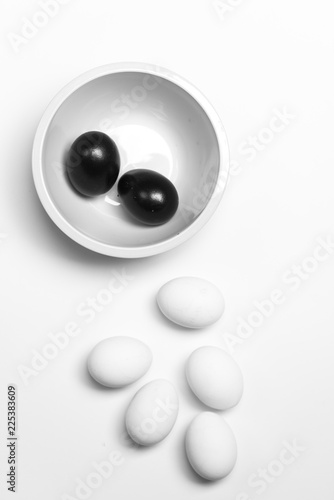 on a white background, white eggs and two black symbolizing diversity, separation, concretion and leadership