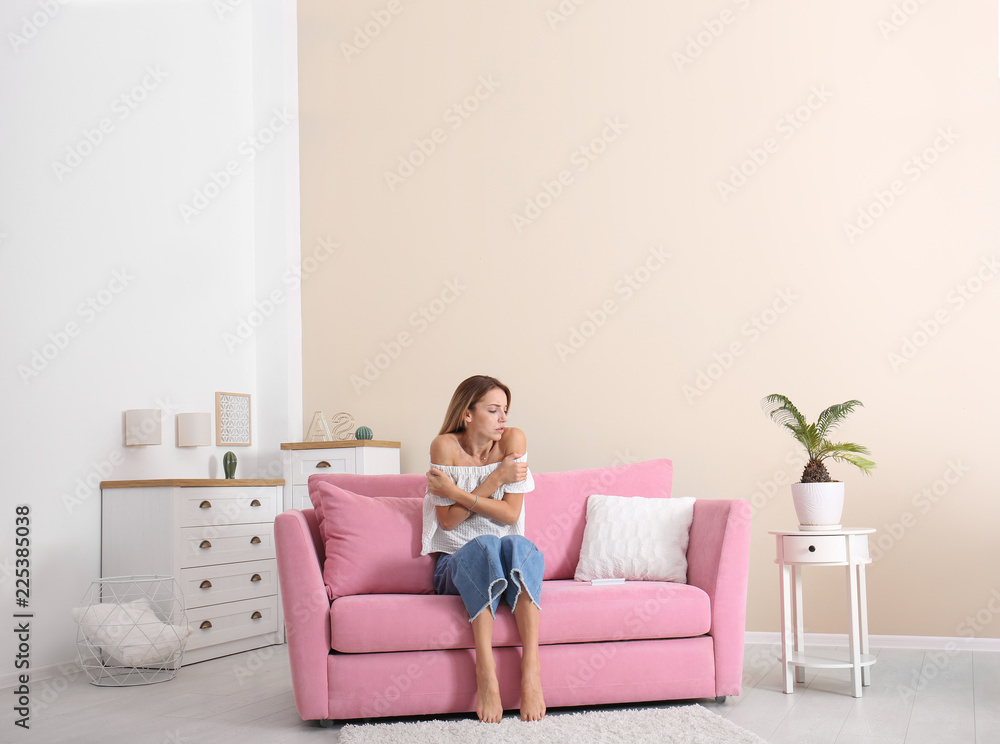 Young woman freezing under air conditioner at home Young woman freezing under air conditioner at home