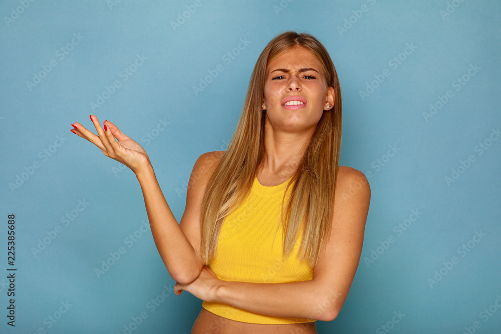 Beautiful young blonde with an angry emotion on her face in the studio Beautiful young blonde with an angry emotion on her face in the studio