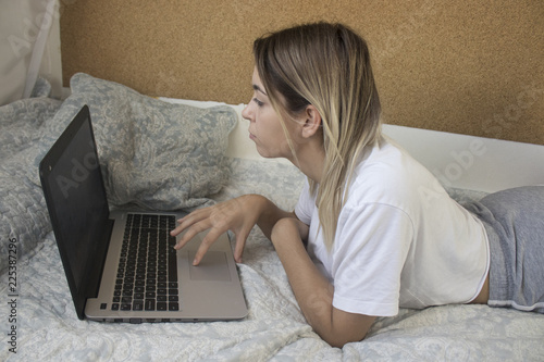 young girl with computer in bed photo
