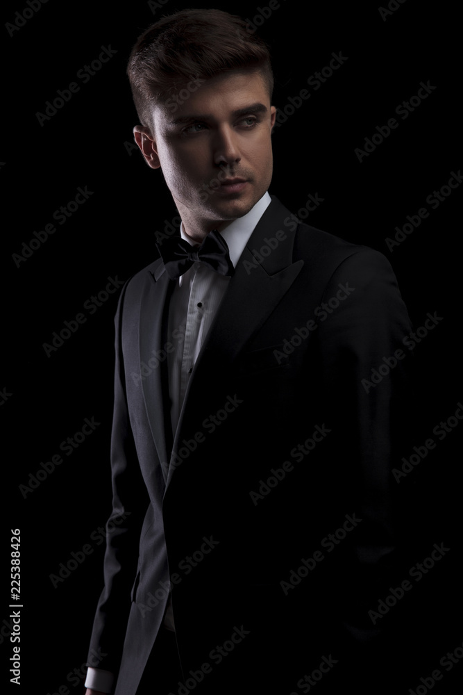portrait of curious man in black tuxedo looking to side portrait of curious man in black tuxedo looking to side