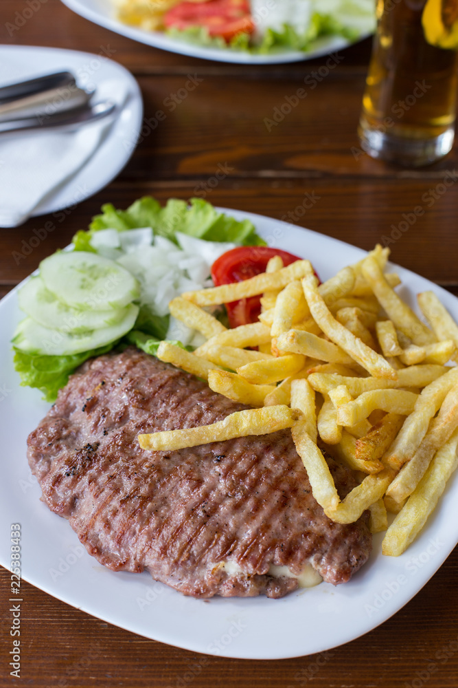 Open hamburger with french fries and salad Open hamburger with french fries and salad