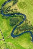 Aerial view on winding river in green field