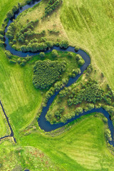Papier peint photo Rivière Rivière serpentant dans champs verdoyants  © eugenegg