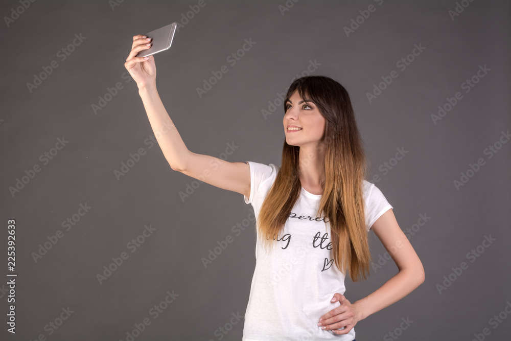 A girl in a white T-shirt makes a selfie on the phone A girl in a white T-shirt makes a selfie on the phone