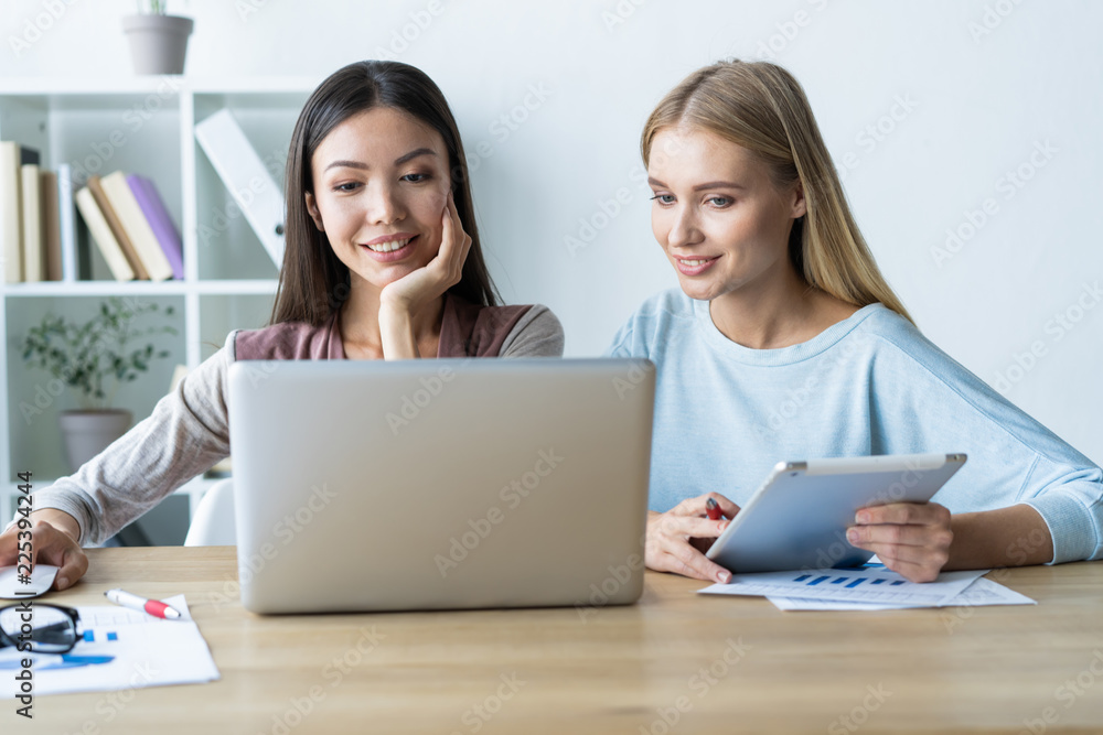 Two female colleagues in office working together. Two female colleagues in office working together.