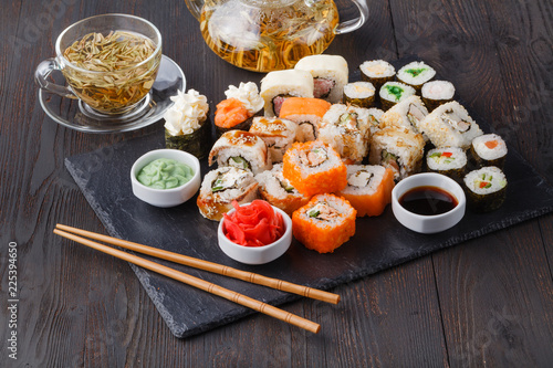Fresh and delicious maki and nigiri sushi rolls and green tea glass