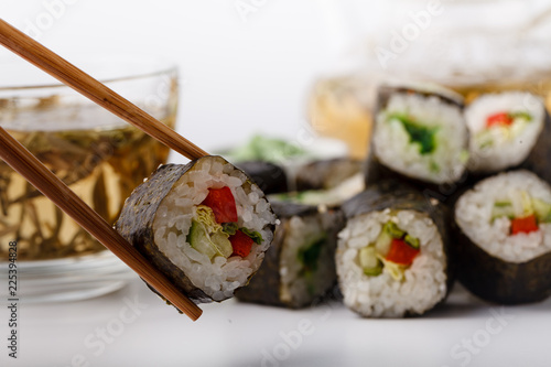 Fresh and delicious maki and nigiri sushi rolls and green tea glass