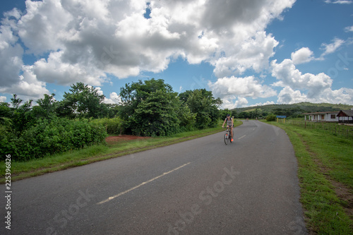 Girl  riding on the bike in Viniales, Cuba photo