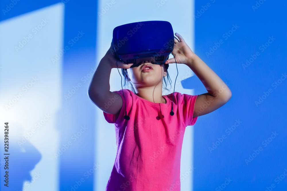 Virtual experiment. Smart cute happy girl touching VR glasses which she wearing when smiling Virtual experiment. Smart cute happy girl touching VR glasses which she wearing when smiling