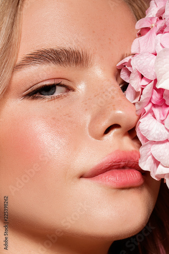 Model with flower. Perfect make up. Beauty. Pink background.