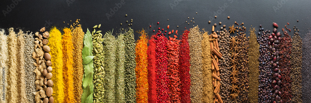 Colorful collection spices and herbs on background black table. Mediterranean condiments for decorating packing with food.