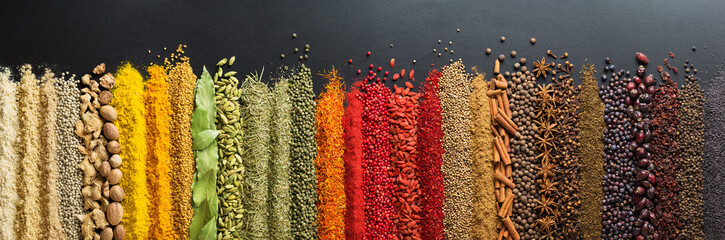 Foto auf Leinwand Küche Bunte Sammlung Gewürze und Kräuter auf schwarzem Hintergrundtisch. Mediterrane Gewürze zum Dekorieren von Verpackungen mit Lebensmitteln.  © dmitr1ch