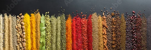 Obraz  z motywem Colorful collection spices and herbs on background black table. Mediterranean condiments for decorating packing with food.