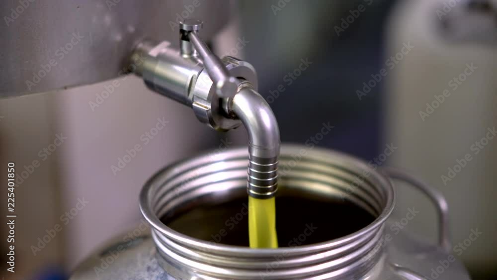 Fresh olive oil fill into a stainless tank. Fresh olive oil fill into a stainless tank.