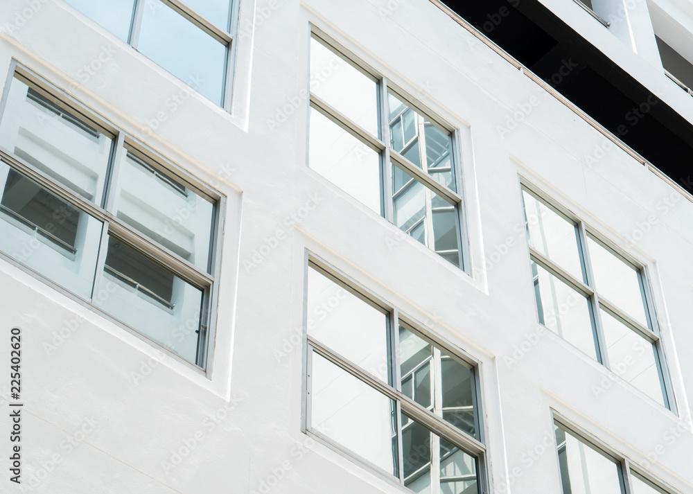 clear glass window on the white wall of high architecture building with reflection clear glass window on the white wall of high architecture building with reflection