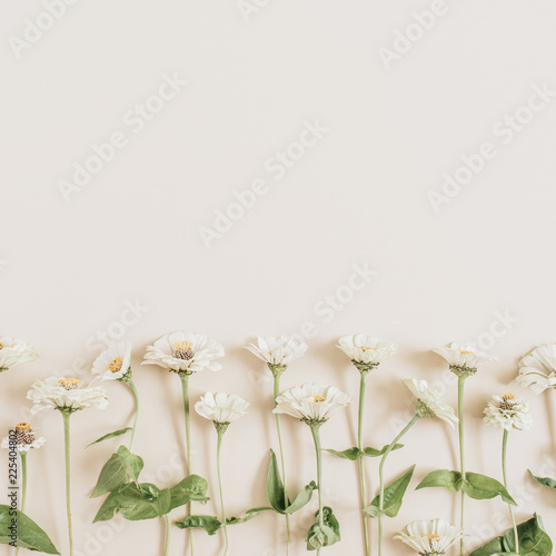 Flowers pattern on beige background. Flat lay, top view.