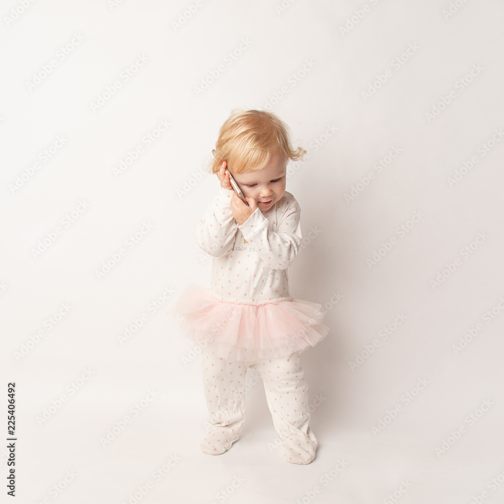 Little blond Girl with Mobile Phone Isolated on White Background. concept a new generation or children and technology Little blond Girl with Mobile Phone Isolated on White Background. concept a new generation or children and technology