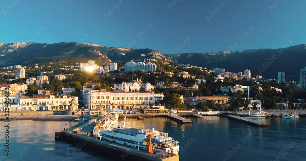 Mountains Peaks, Sunset Sea and the city. Epic on the edge of the mountain valley with rocks and sun flare. 4k drone flight. Aerial establisher, Sudak. Europe green nature. Film vintage colors. Mountains Peaks, Sunset Sea and the city. Epic on the edge of the mountain valley with rocks and sun flare. 4k drone flight. Aerial establisher, Sudak. Europe green nature. Film vintage colors.