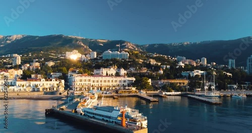 Mountains Peaks, Sunset Sea and the city. Epic on the edge of the mountain valley with rocks and sun flare. 4k drone flight. Aerial establisher, Sudak. Europe green nature. Film vintage colors.