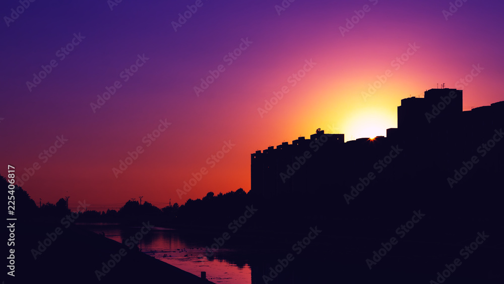 colorful purple sunset and buildings in the dark shade