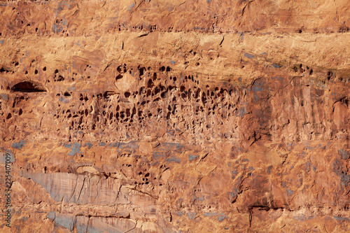 Red slickrock formation with tafoni or water holes found along the Colorado River outside of Moab Utah