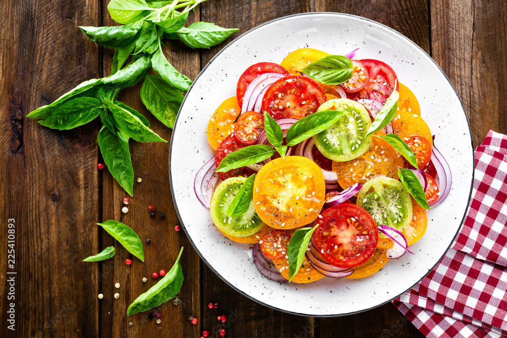 Tomato salad. Fresh vegetable salad with tomatoes, onion and basil Tomato salad. Fresh vegetable salad with tomatoes, onion and basil