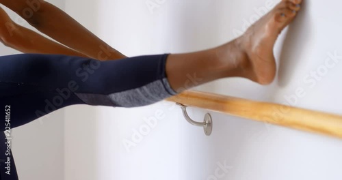 Woman stretching on barre in fitness studio 4k photo