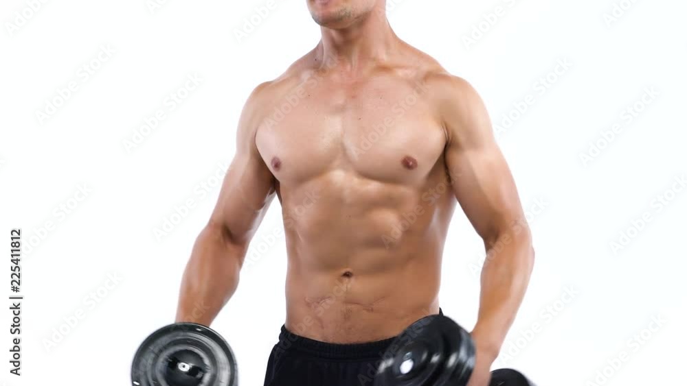 Man flexes his hands with dumbbells, training his shoulders on a white background in the studio Man flexes his hands with dumbbells, training his shoulders on a white background in the studio