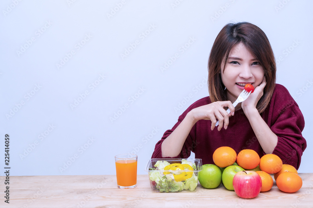 Healthy food concept. Attractive young woman having breakfast with salad vegetarian, fruit and juice on white background. Smiling girl eating fresh salad for health with apple and orange. Healthy food concept. Attractive young woman having breakfast with salad vegetarian, fruit and juice on white background. Smiling girl eating fresh salad for health with apple and orange.