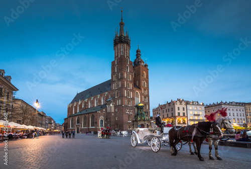 Old town market square of Krakow, Poland with horse carriages.