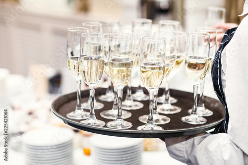 Elegant glasses with champagne standing in a row on serving tabl