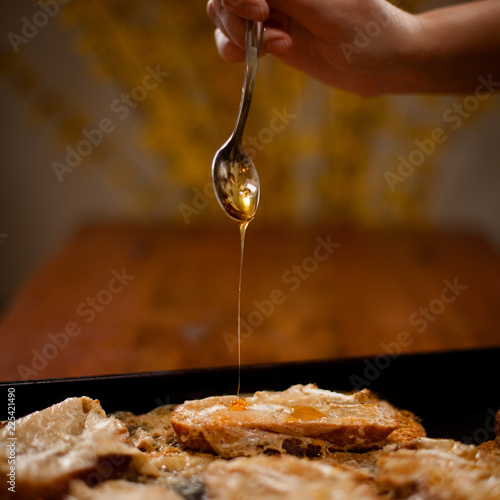 Hand pouring honey on toast