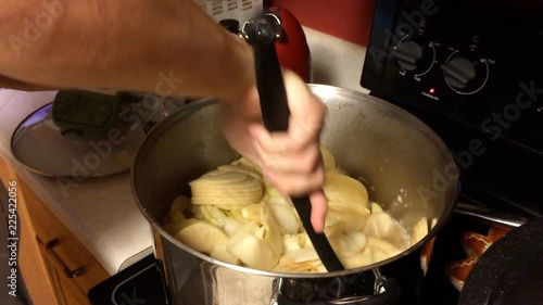 Man making applesauce on kitchen stove