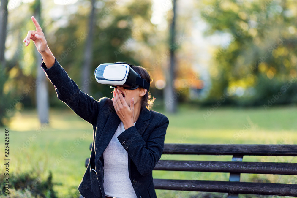 Modern business woman using VR headset in a park Modern business woman using VR headset in a park