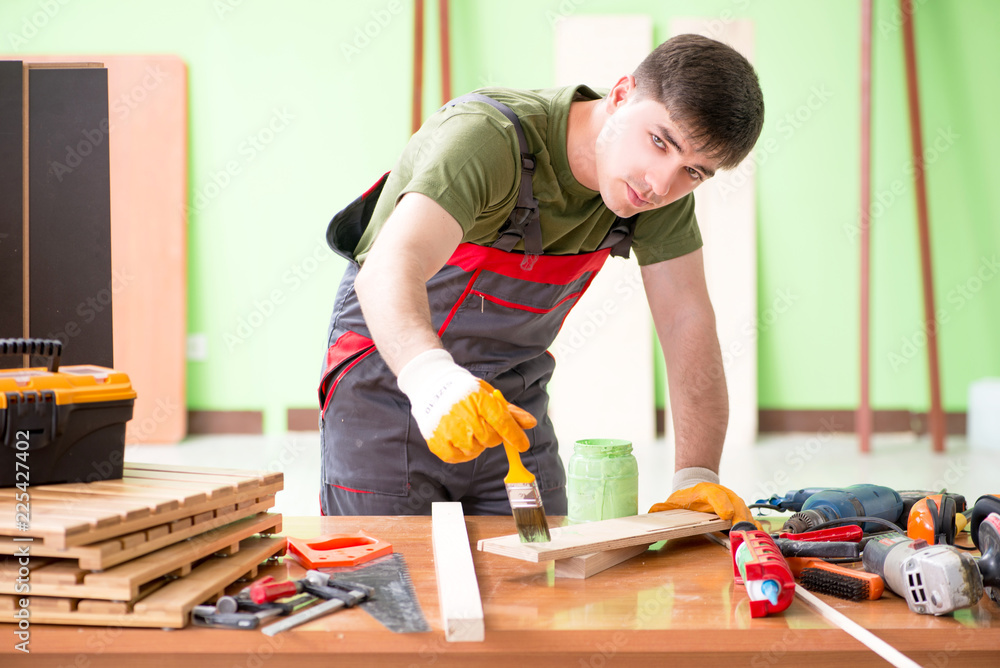 Young man carpenter working in workshop Young man carpenter working in workshop