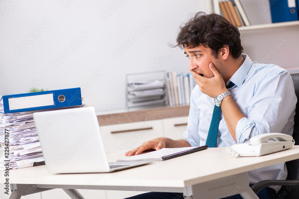 Overloaded busy employee with too much work and paperwork Overloaded busy employee with too much work and paperwork